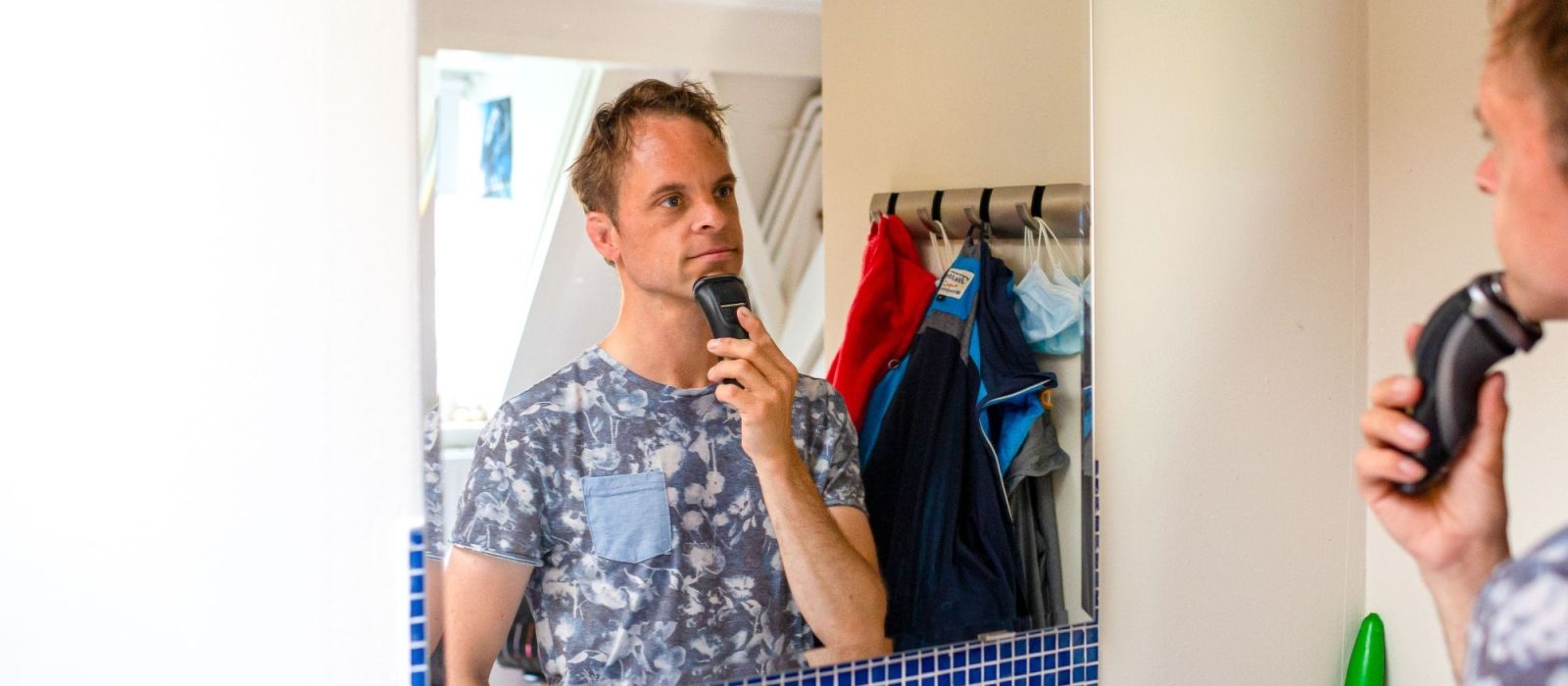 cliënt voor een spiegel die zich aan het scheren is