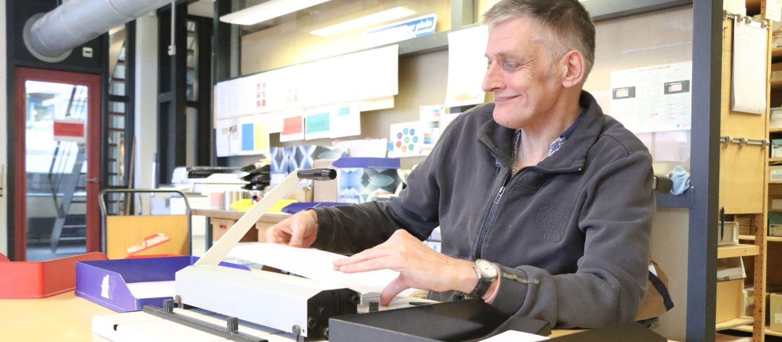 Een medewerker van De Ruimte snijdt papier
