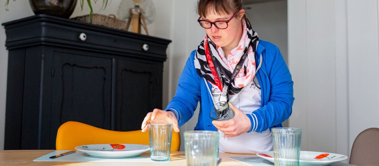 Jonge vrouw dekt de eettafel