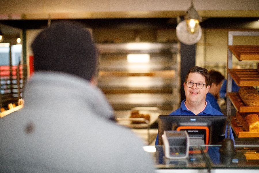 cliënt achter de kassa bij zorgbakkerij Het Blauwe Hek