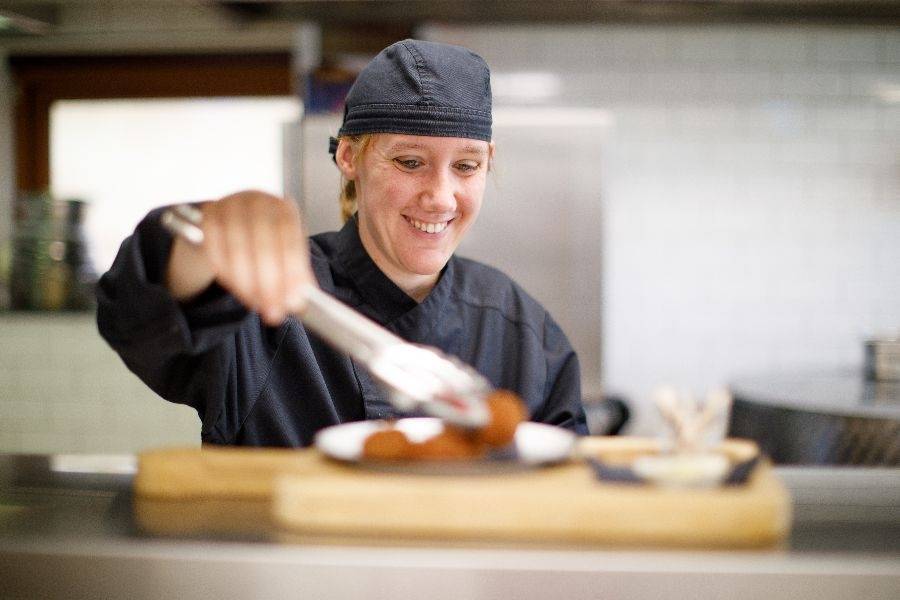 Medewerker aan het werk in de keuken van lunchcafé De Smulhoeve