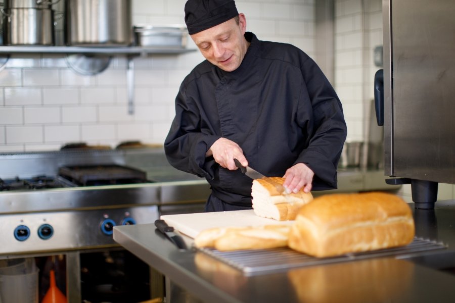 Cliënt die brood aan het snijden is